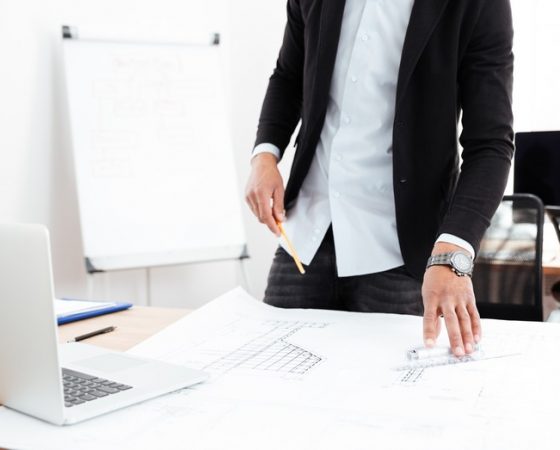 Cropped image of a businessman standing at the desk with documents in office